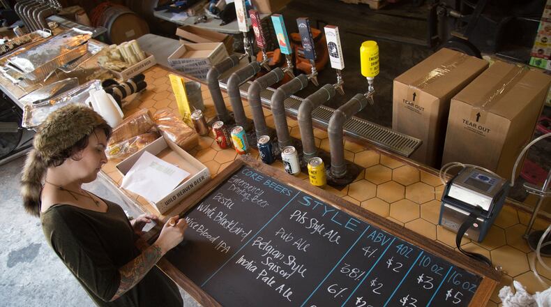 Angela Riley, brand manager at Wild Beer Heaven Brewery, works on a new beer menu in preparation for Friday, when the brewery will be allowed to sell beer directly to customers. STEVE SCHAEFER / SPECIAL TO THE AJC