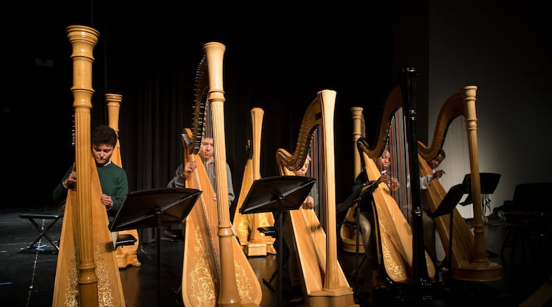 Drew Charter School freshman Aryka DeRose (left) plays her harp along with her classmates during practice. STEVE SCHAEFER / SPECIAL TO THE AJC