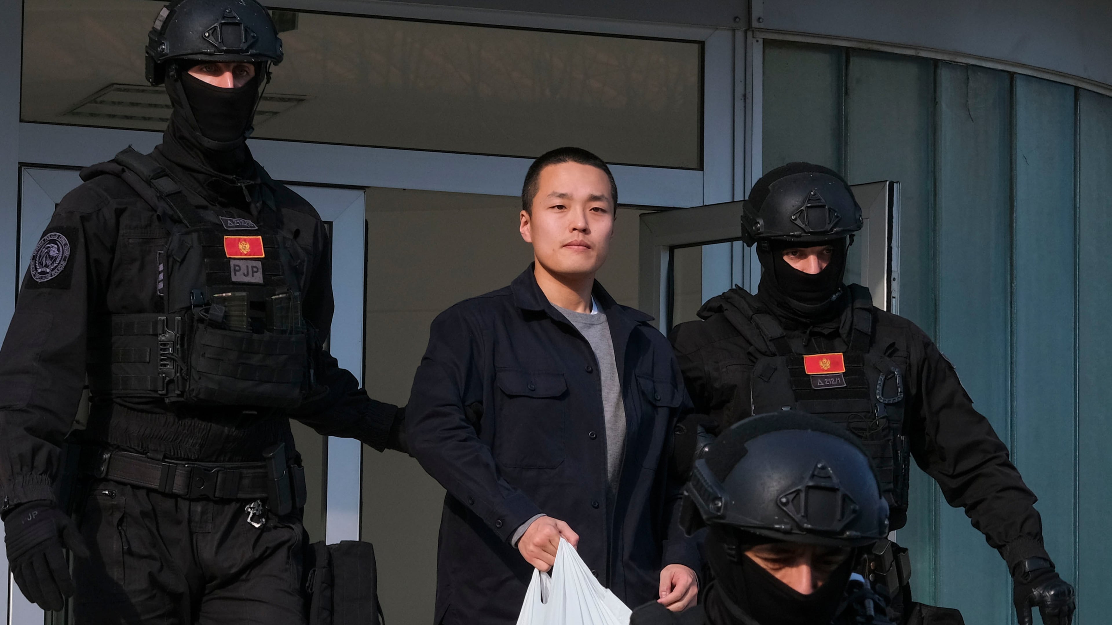 FILE - Montenegrin police officers escort South Korean citizen, Terraform Labs founder Do Kwon in Montenegro's capital Podgorica, March 23, 2024. (AP Photo/Risto Bozovic, File)