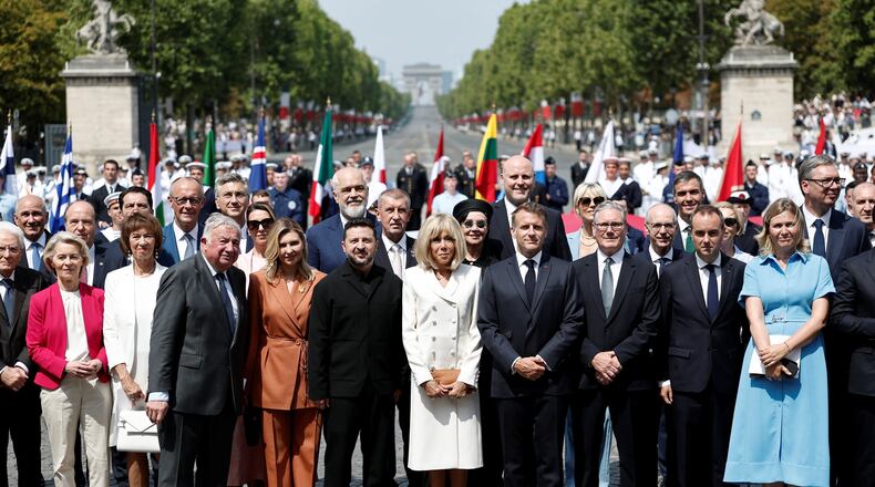 French President Emmanuel Macron, his wife Brigitte Macron, Ukraine's President Volodymyr Zelenskyy and his wife Olena Zelenska, Heads of State and Government of the Coalition of the Willing, President of the National Assembly Yael Braun-Pivet, and President of the Senate Gerard Larcher pose for a family photo after the annual Bastille Day military parade on the Place de la Concorde in Paris, France, Tuesday, July 14, 2026. (Benoit Tessier/Pool photo via AP)