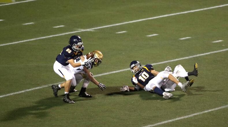 Marist wide receiver Matthew Houghton (80) catches a tipped pass for a touchdown against St. Pius defender Jacob Pajer (24) and wide receiver Kyle Hamilton (10) in the second half of the semi-final of the Class AAAA state playoffs at Marist School Friday, December 1, 2017, in Atlanta. PHOTO / JASON GETZ