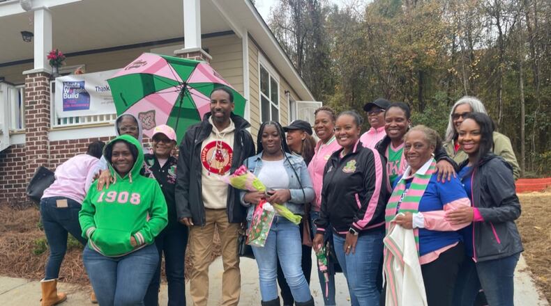 Atlanta Mayor Andre Dickens, Pi Alpha Omega president Brianca Martin, and chapter members stand with homeowner Tekia Rice (center, holding flowers) at her home dedication last month. She'll move in just before Christmas and have a 7-foot tree, compliments of one of the sorority sisters to enhance the celebration. Photo courtesy of Pi Alpha Omega.
