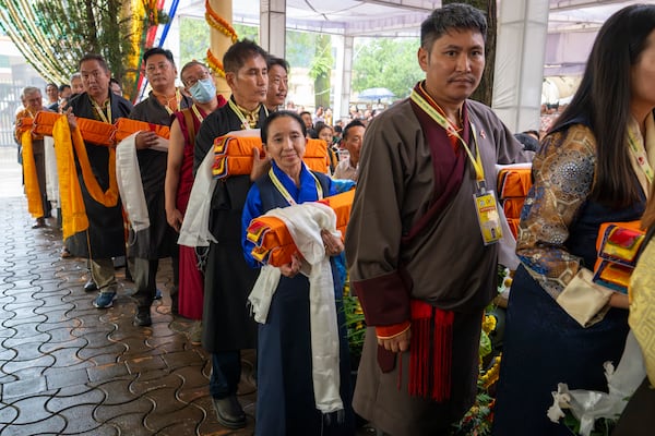 Exile Tibetans wait with ceremonial offerings for their spiritual leader the Dalai Lama at an event during which Tibetan exiles prayed for the Tibetan leader's longevity, a day before his 90th birthday, in Dharamshala, India, Saturday, July 5, 2025.(AP Photo/Ashwini Bhatia)