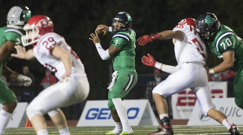 Harrison quarterback Justin Fields (1) drops back to pass as Dalton defensive end Kevin Diaz (56) is blocked by lineman Tonny Garcia (70) and linebacker Jack Ridley (29) is blocked by Dawson Brown, left, during a high school football game on Thursday, Oct. 19, 2017, in Kennesaw, Ga. (Special to the Atlanta Journal-Constitution, John Amis )