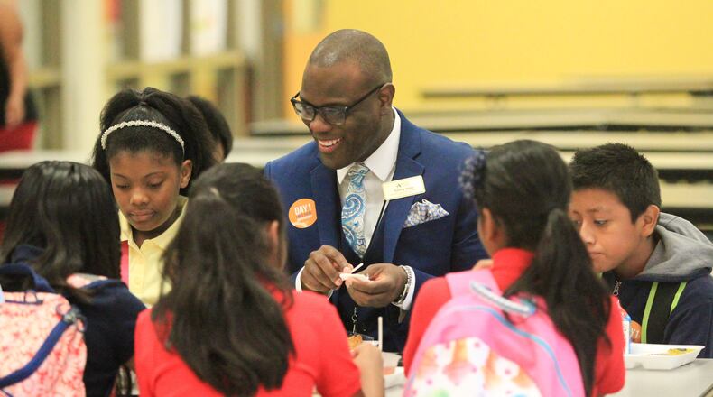 Tommy Usher, Atlanta Public Schools’ associate superintendent of schools k-8, eats breakfast with Garden Hills Elementary School students before class starts in August. EMILY JENKINS/ EJENKINS@AJC.COM