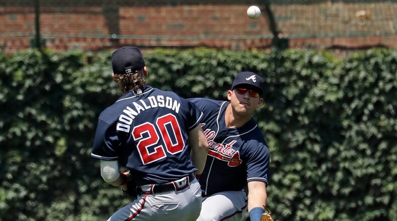 Atlanta Braves left fielder Austin Riley, right, can't make the play on a single by Chicago Cubs' Anthony Rizzo as third baseman Josh Donaldson (20) watches on during the first inning of a baseball game in Chicago, Thursday, June 27, 2019. (AP Photo/Nam Y. Huh)