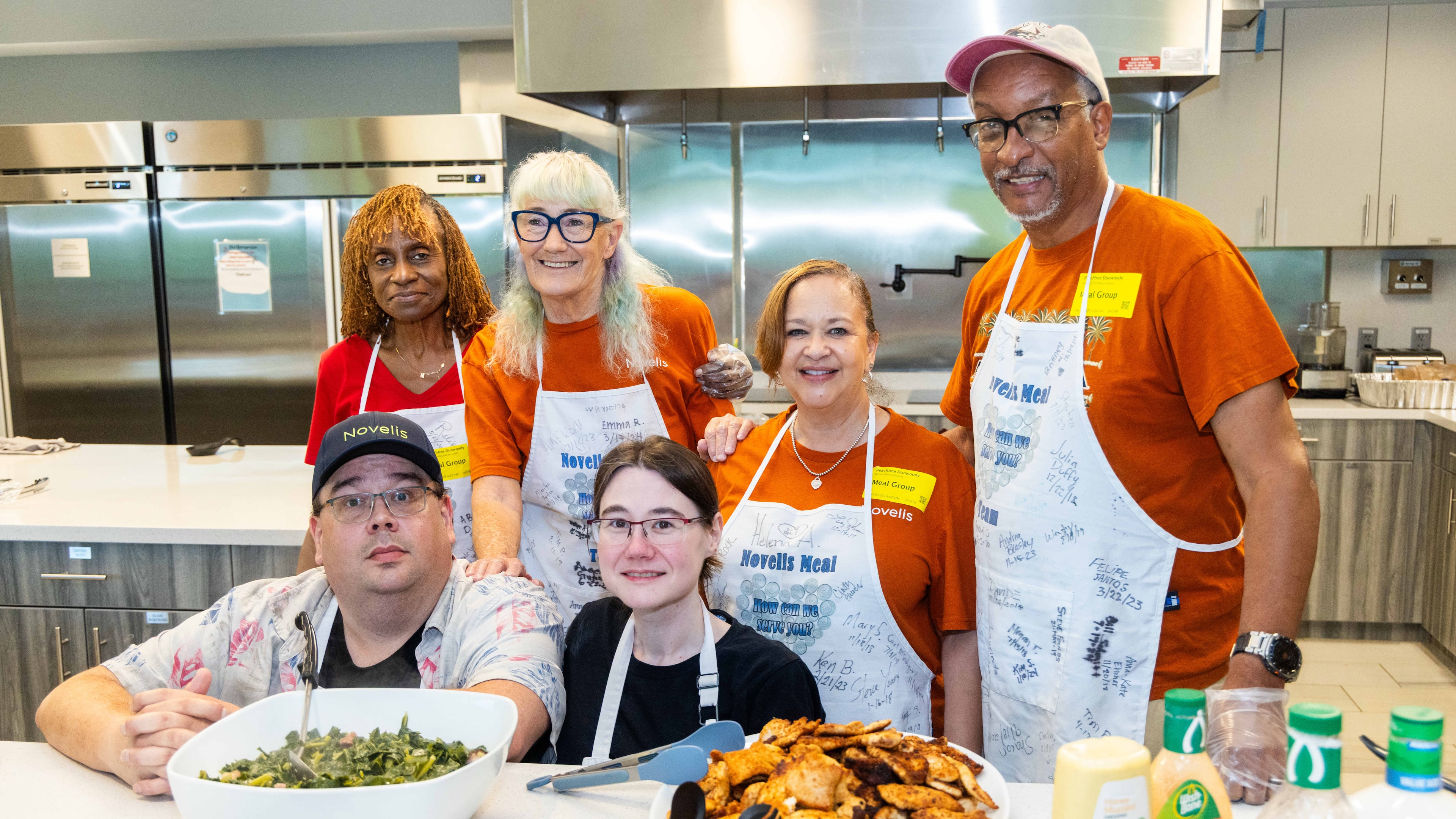 Volunteers Marlena Williams (clockwise from top left), Mary Stockstill, Danise St Andrew, Maurice Calhoun, Bethany and Carl Mosadoques show off the dinner they prepared for guests at the Ronald McDonald House in Atlanta. (Phil Skinner for the AJC)