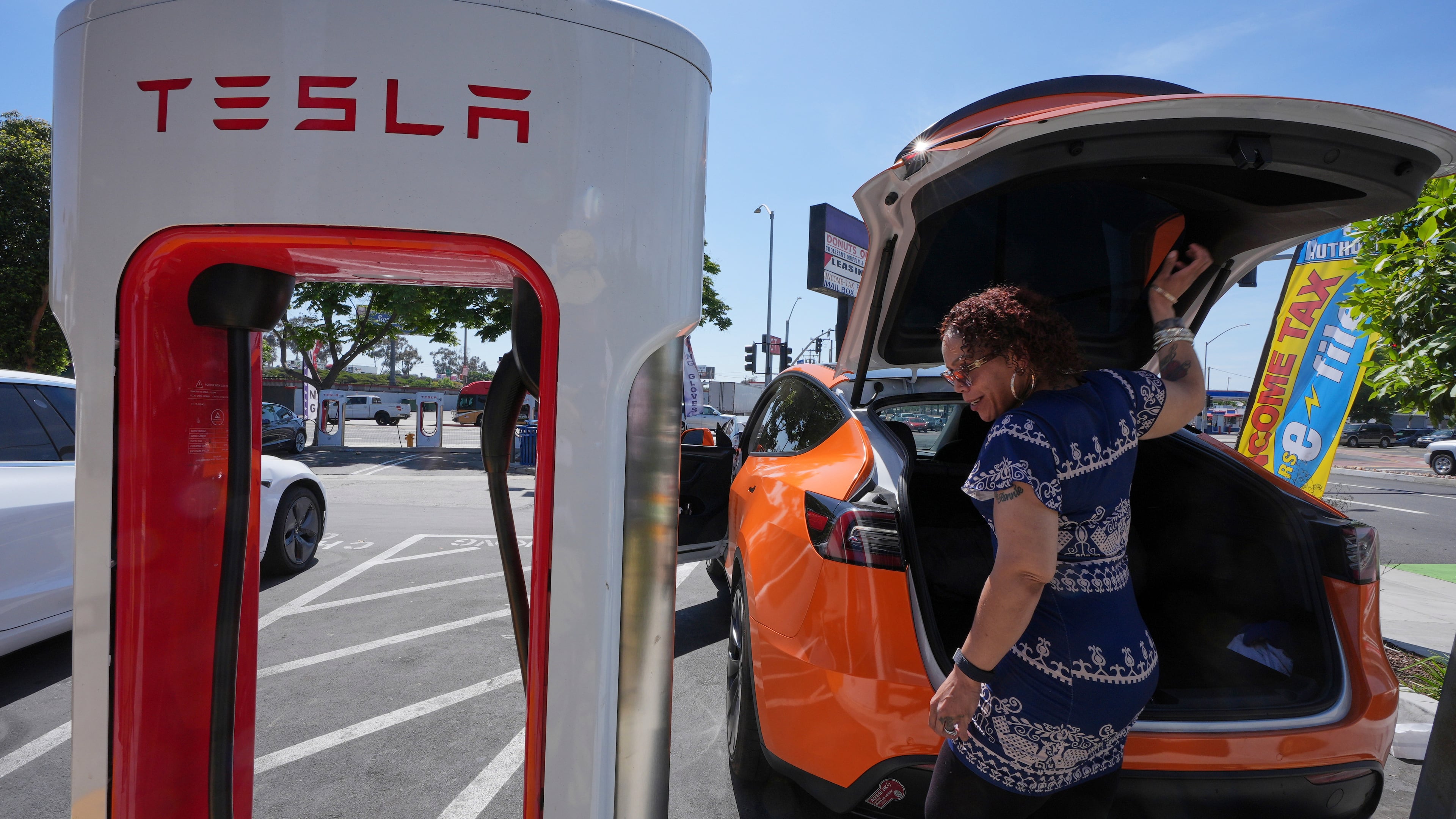 FILE - Janelle Lowe prepares to charge her electric vehicle at a station May 22, 2025, in Long Beach, Calif. (AP Photo/Damian Dovarganes, File)
