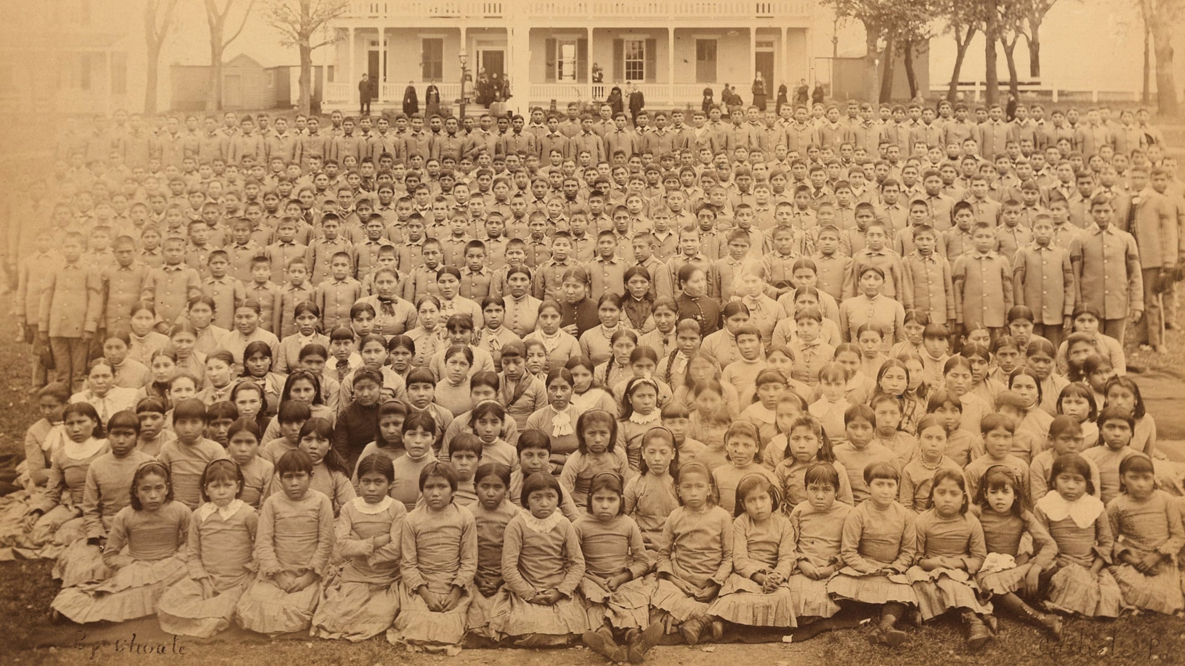 This photo provided by the Carlisle Indian School Digital Resource Center shows the Carlisle Indian Industrial School student body in front of the superintendent's house in Carlisle, Pa., circa 1885. (John N. Choate/Carlisle Indian School Digital Resource Center via AP)