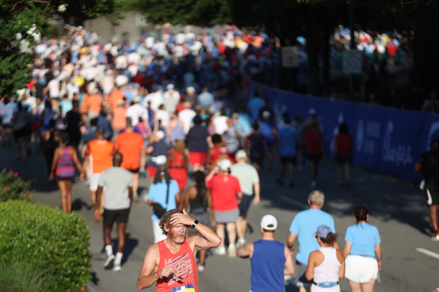 Runners make wita to starting line at the 56th running of the Atlanta Journal-Constitution Peachtree Road Race in Atlanta on Friday, July 4, 2025.   (Arvin Temkar / AJC)