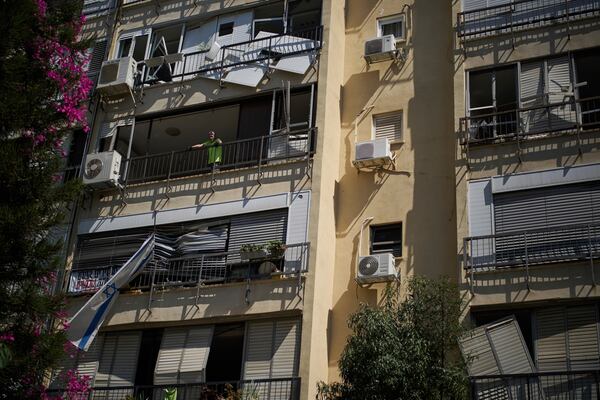 Yuval, 65, looks out from the window of his damaged apartment a day after of an Iranian missile strike in Ramat Gan, Israel, Friday, June 20, 2025. (AP Photo/Leo Correa)