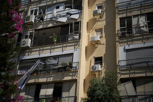 Yuval, 65, looks out from the window of his damaged apartment a day after of an Iranian missile strike in Ramat Gan, Israel, Friday, June 20, 2025. (AP Photo/Leo Correa)