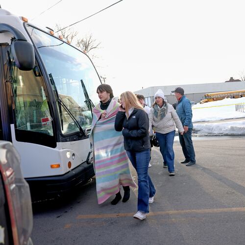 High school hockey students walk onto a public transit bus near the Lynch Arena in Pawtucket, R.I., after a shooting at the ice rink, Monday, Feb. 16, 2026. (AP Photo/Mark Stockwell)