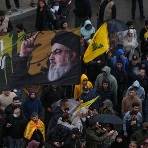 A Hezbollah supporter waves a flag with the portrait of the late Hezbollah leader Sayyed Hassan Nasrallah during a protest against the Lebanese Prime Minister Nawaf Salam, in front the government palace in Beirut, Lebanon, Friday, April 10, 2026. (AP Photo/Hussein Malla)