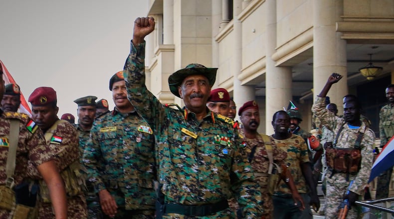 FILE - Sudan's military chief Gen. Abdel-Fattah Burhan, center, is greeted by troops as he arrives at the Republican Palace, recently recaptured from the Rapid Support Forces (RSF) paramilitary group, in Khartoum, Sudan, March 26, 2025. (AP Photo/File)