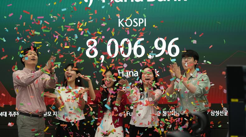 Employees of Hana Bank celebrate in a photo-op to mark the Korea Composite Stock Price Index (KOSPI) of over 8,000 points at a dealing room of Hana Bank in Seoul, South Korea, Friday, May 15, 2026. (AP Photo/Lee Jin-man)