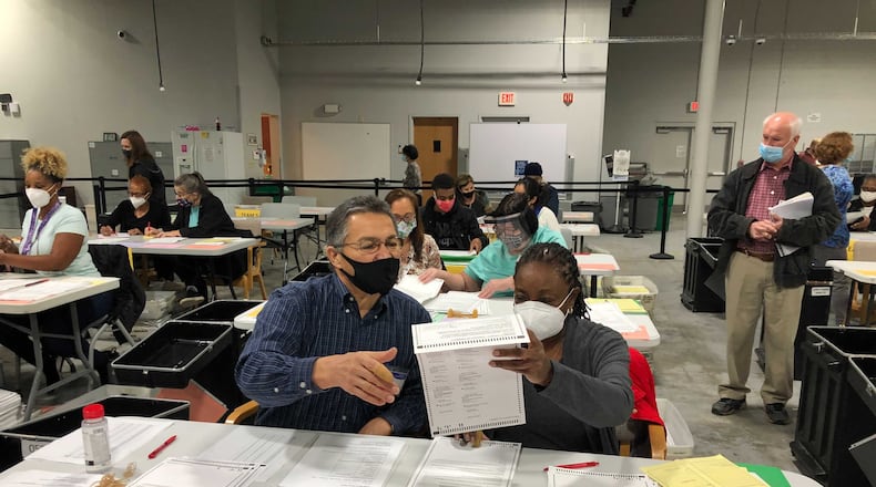 Gwinnett County elections workers count absentee by mail at the county elections building in Lawrenceville.