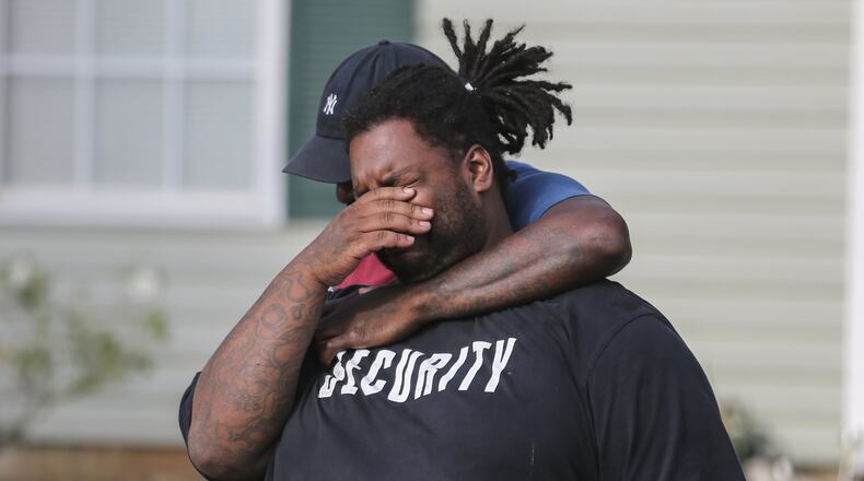 Anthony Lewis grieves at the scene where his brother, Cedric Clark was found dead Wednesday. The body of Cedric Clark, 17, was found by a homeowner in the 5800 block of Eagles Feather Lane, about a mile from his Riverdale home, Clayton County police Deputy Chief Joseph Woodall said. JOHN SPINK /JSPINK@AJC.COM