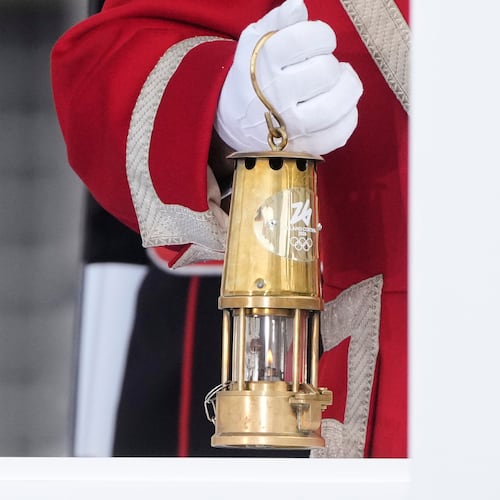 A cuirassier holds the torch lantern prior to the Milan Cortina 2026 Winter Olympics cauldron lighting, in front of the Quirinale Presidential Palace, in Rome, Friday Dec. 5, 2025. (AP Photo/Gregorio Borgia)
