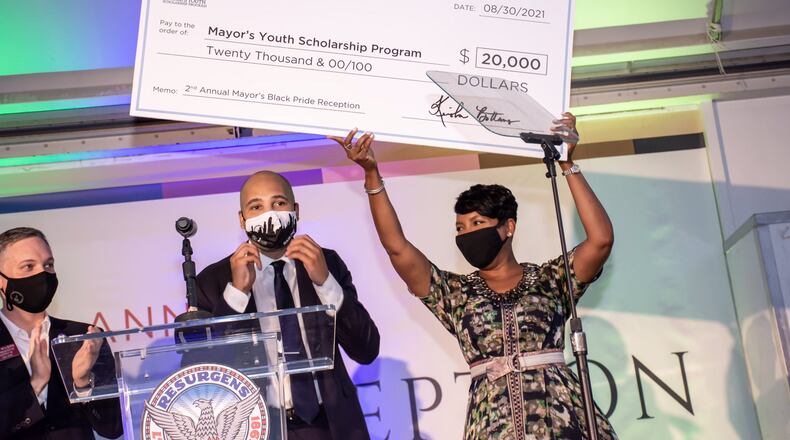 Atlanta Mayor Keisha Lance Bottoms raises a check in celebration of the more than $30,000 raised at her reception for the kick off of Black Pride weekend. CONTRIBUTED