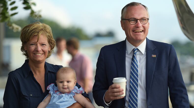 Lt. Gov. Casey Cagle, right, and his wife, Nita Cagle, who is holding their youngest granddaughter, walk out to a plane to do a statewide fly around the day before the Election Day runoff on Monday at Epps Aviation at the Dekalb-Peachtree Airport. Jenna Eason, Jenna.Eason@coxinc.com