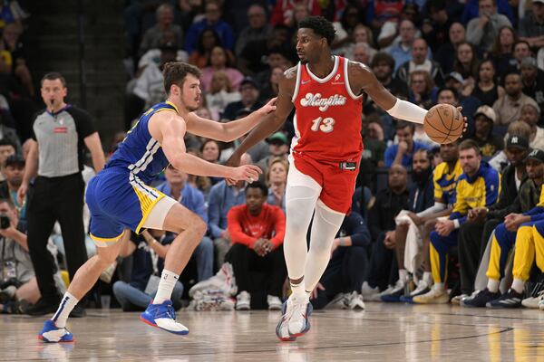 Memphis Grizzlies forward Jaren Jackson Jr. (13) handles the ball against Golden State Warriors center Quinten Post in the first half of an NBA basketball game, Tuesday, April 1, 2025, in Memphis, Tenn. (AP Photo/Brandon Dill)