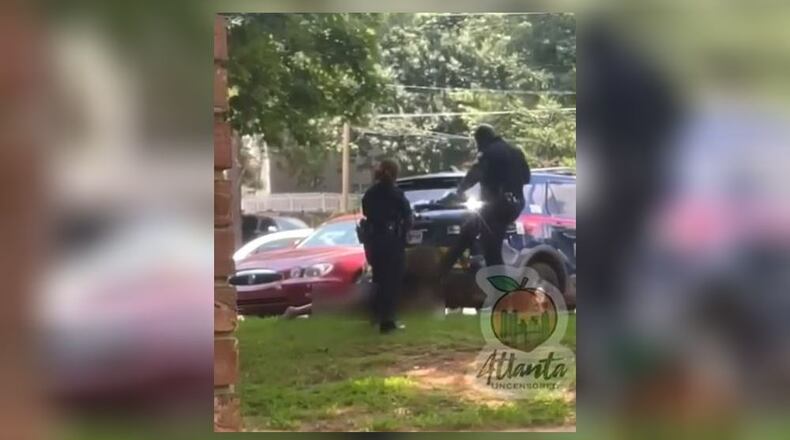 Two Atlanta police officers were suspended after a video surfaced on social media that shows one of them kicking a woman in the face as she lay handcuffed on the ground.