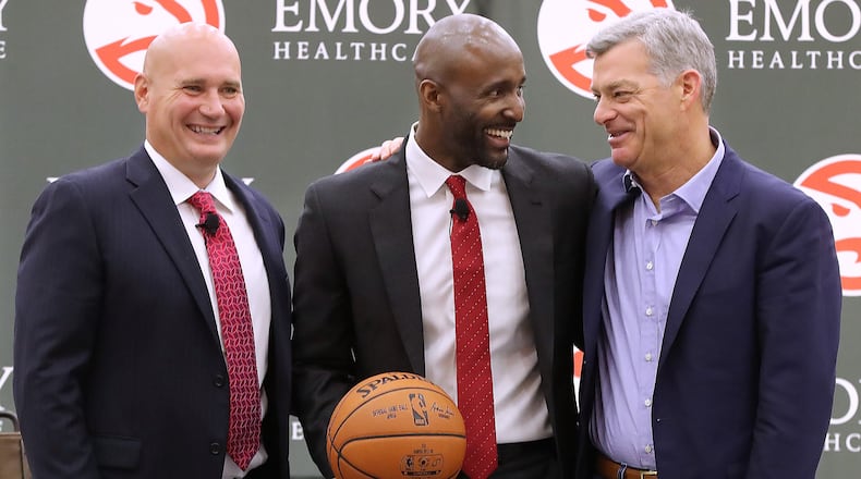 Hawks general manager Travis Schlenk (left) and owner Tony Ressler (right), along with coach Lloyd Pierce.   Curtis Compton/ccompton@ajc.com