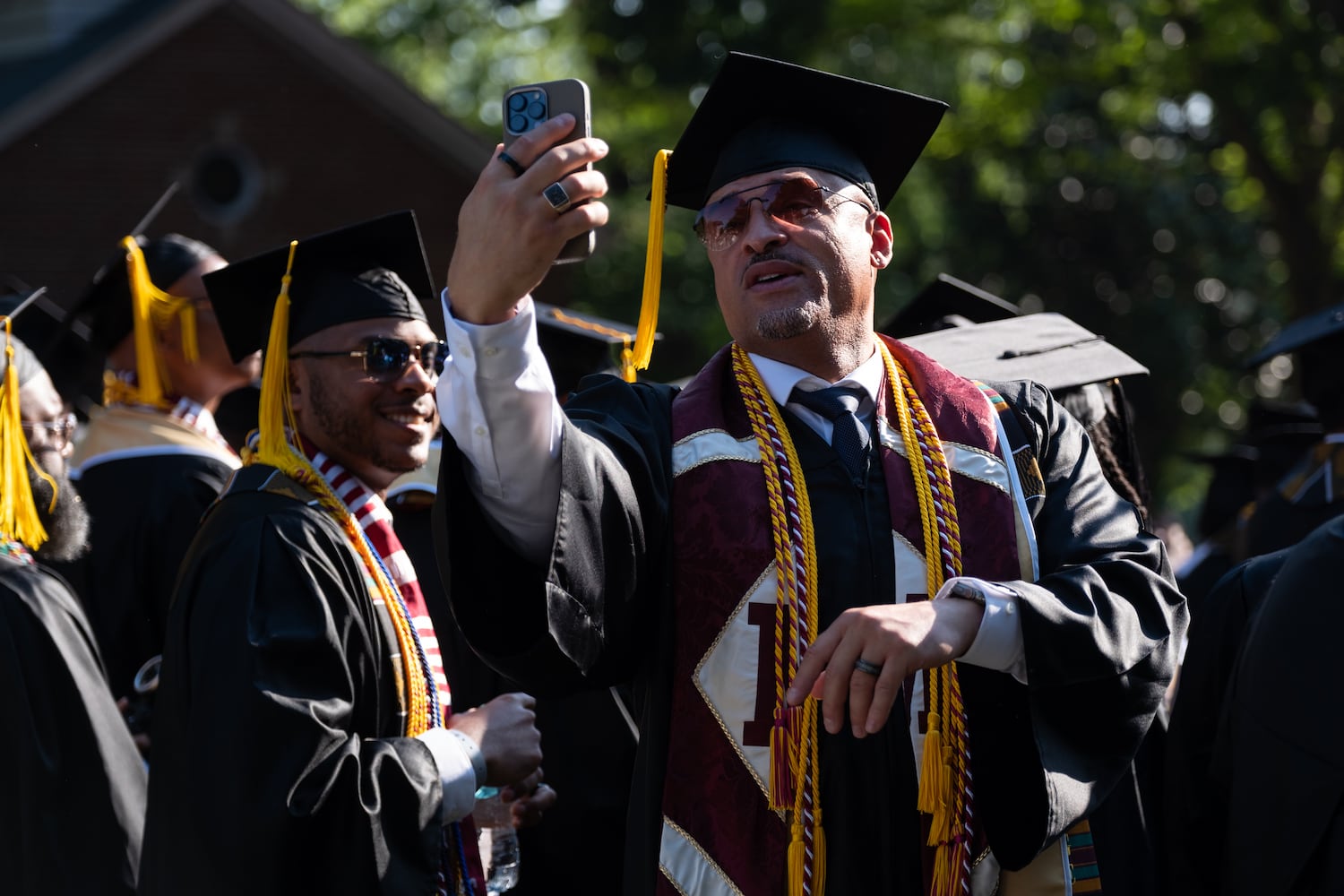A student takes a selfie before the Morehouse College graduation Sunday, May 17, 2026. (Ben Gray for the AJC)