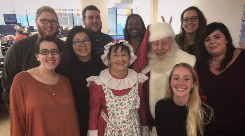 Santa and Mrs. Claus visit the AJC’s Hyperlocal team. Back row, L to R, Cobb Reporter Ben Brasch, N. Fulton Reporter Mitch Northam, Hyperlocal Coach Janel Davis, Intown Atlanta Reporter Becca Godwin, Middle row, SEO Content Producer Courtney Martinez, Hyperlocal Senior Editor Melissa Hall, Mrs. Santa Claus, Santa Claus, Gwinnett Reporter Amanda Coyne. Kneeling, Social Media Producer Kelly Audette. Not pictured is DeKalb Reporter Joshua Sharpe.