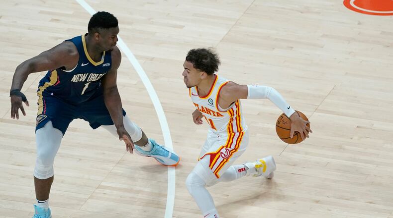 Atlanta Hawks guard Trae Young (11) works against New Orleans Pelicans forward Zion Williamson (1) in the first half of an NBA basketball game Tuesday, April 6, 2021, in Atlanta. (AP Photo/John Bazemore)
