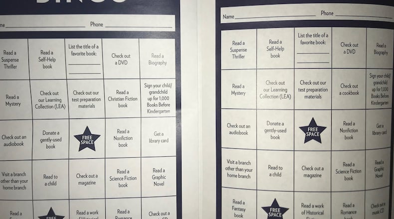 The bingo card on the left is the one originally distributed by the DeKalb County library system, and it included a prompt to “read a Christian fiction book.” After complaints, the library created new versions that says “Check out a cookbook.” (Tia Mitchell/tia.mitchell@ajc.com)
