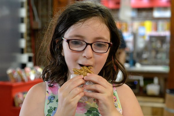 Abigile Biddle, 9, visiting River Street Sweets with her parents from Charleston eats a praline. On Wednesday's National Praline Day, River Street Sweets, Savannah's Candy Kitchen along with parent companies River Street Sweets and Savannah Candy Kitchen will donate 10 percent of all praline sales to the America's Second Harvest's Kids Cafe.