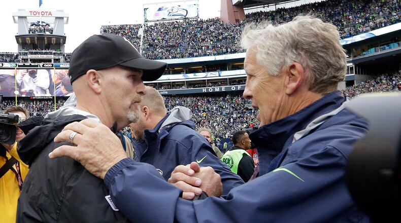 Seattle Seahawks head coach Pete Carroll, right, greets Atlanta Falcons head coach Dan Quinn after an NFL football game, Sunday, Oct. 16, 2016, in Seattle. (AP Photo/Elaine Thompson)