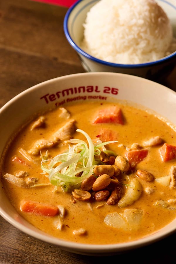 A bowl of Massaman curry at Terminal 26, flanked by a bowl of jasmine rice.