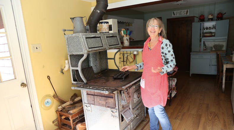 Barbara Swell stands beside the 1928 wood stove she uses to teach cooking classes in her log cabin in Asheville, N.C. Swell is the author of 11 cookbooks that feature recipes from the 19th and 20th centuries. She continues to collect South Appalachian recipes, oral histories and folklore from longtime mountain residents. TYSON HORNE / TYSON.HORNE@AJC.COM