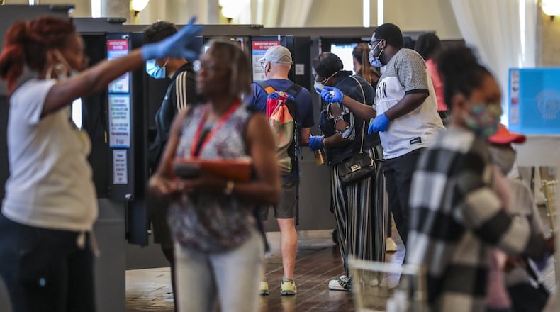 Poll workers respond to early glitches at the Park Tavern polling place located at 500 10th St NE, on Tuesday, June 9, 2020 in Atlanta. Many voters said they requested absentee ballots but never received them. Two lines, 300-yards long each formed parallel to Piedmont park in the parking lot as people patiently waited to vote. JOHN SPINK/JSPINK@AJC.COM