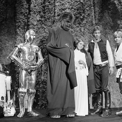 FILE - Kenny Baker, from left, Anthony Daniels, Peter Mayhew, Carrie Fisher, Harrison Ford and Mark Hamill are seen during the filming of the CBS-TV special, "The Star Wars Holiday," in Los Angeles, Nov. 13, 1978. (AP Photo/George Brich, File)