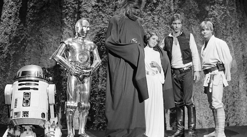 FILE - Kenny Baker, from left, Anthony Daniels, Peter Mayhew, Carrie Fisher, Harrison Ford and Mark Hamill are seen during the filming of the CBS-TV special, "The Star Wars Holiday," in Los Angeles, Nov. 13, 1978. (AP Photo/George Brich, File)
