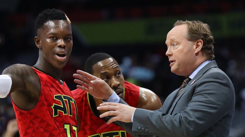 Hawks coach Mike Budenholzer confers with guard Dennis Schroder and center Dwight Howard during Sunday's loss to the Brooklyn Nets. (Curtis Compton/ccompton@ajc.com)
