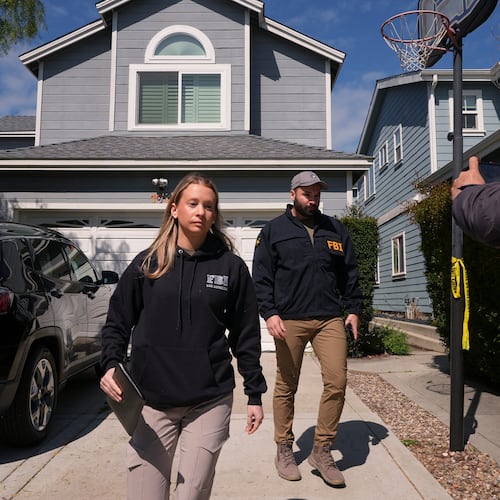 FBI agents walk door to door to try to speak with neighbors as members of the media follow them, Sunday, April 26, 2026, near an address in Torrance, Calif., connected to Cole Tomas Allen, who was identified as the shooting suspect at the White House Correspondents Dinner the night before. (AP Photo/Damian Dovarganes)