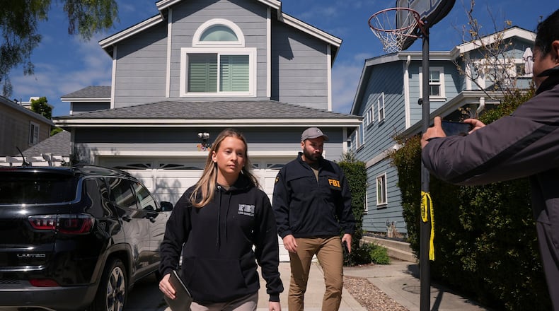 FBI agents walk door to door to try to speak with neighbors as members of the media follow them, Sunday, April 26, 2026, near an address in Torrance, Calif., connected to Cole Tomas Allen, who was identified as the shooting suspect at the White House Correspondents Dinner the night before. (AP Photo/Damian Dovarganes)