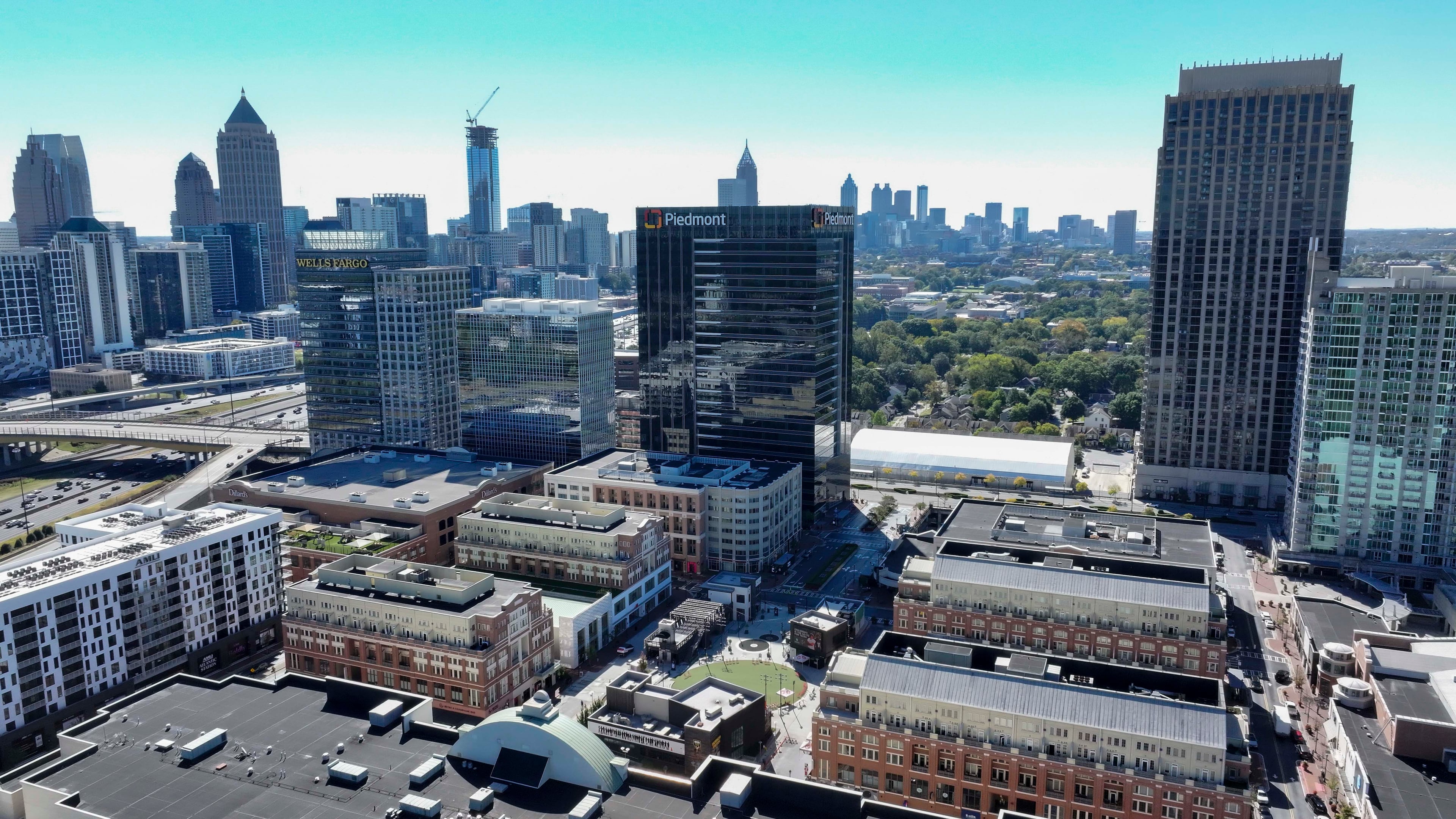 An aerial image shows the main square at Atlantic Station with the Atlanta skyline in the background on Thursday, Oct. 16, 2025. (Miguel Martinez/AJC)