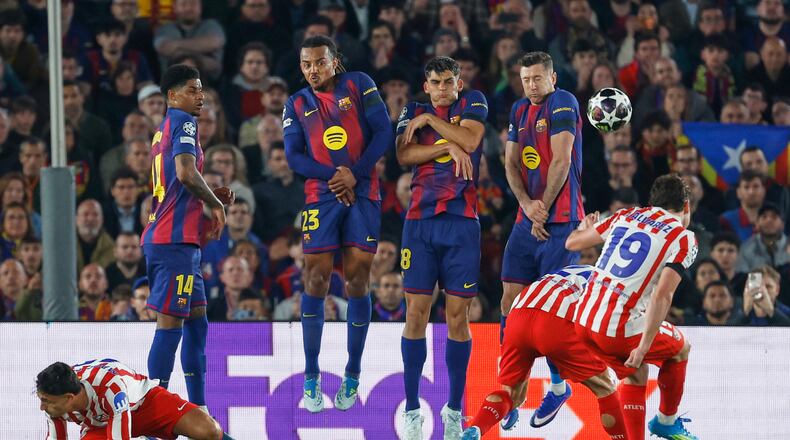 Atletico Madrid's Julian Alvarez, right, takes a free kick during the Champions League quarterfinal first leg soccer match between Barcelona and Atletico Madrid in Barcelona, Spain, Wednesday, April 8, 2026. (AP Photo/Joan Monfort)