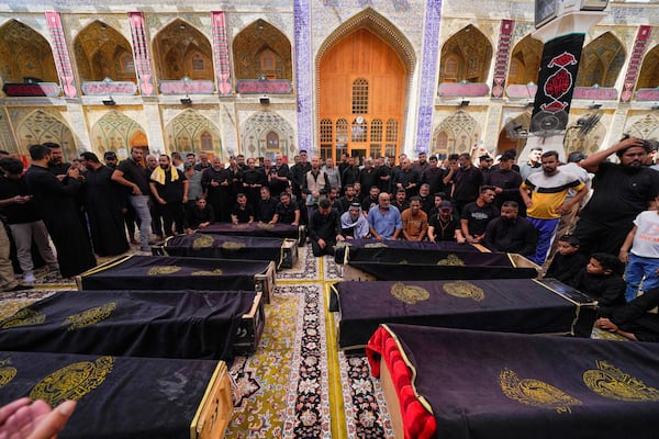 Mourners attend the funeral of victims who died in a fire at a shopping center in Kut, at the shrine of Imam Ali in Najaf, Iraq, Thursday, July 17, 2025. (AP Photo/Anmar Khalil)