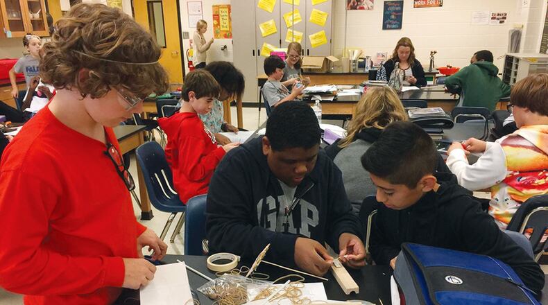 Classmates at Woodstock’s E.T. Booth Middle School (from left) Riley Mostyn, Miguel Morgan and Ramon Mandujano collaborate on a project on Newton’s Third Law (For every action, there is an equal and opposite reaction) by building balloon-powered cars. The Cherokee County schools have renewed a partnership agreement calling for cooperation with the county. CHEROKEE COUNTY SCHOOL DISTRICT