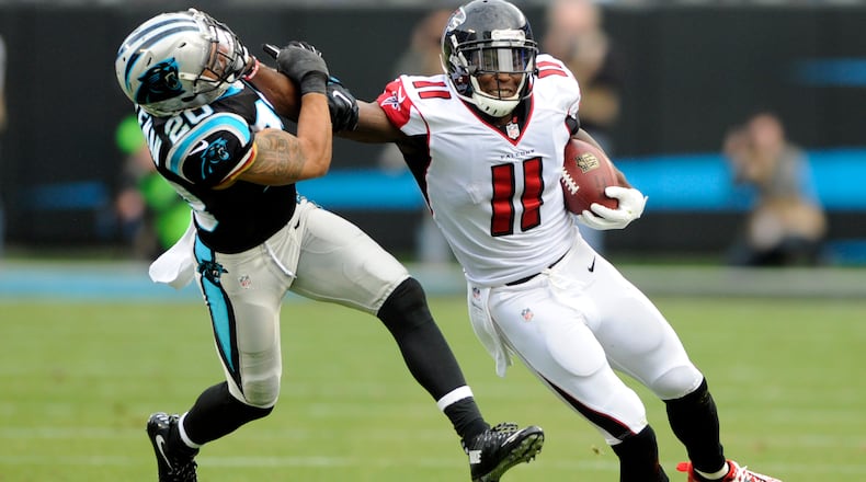 Atlanta Falcons' Julio Jones (11) pushes away Carolina Panthers' Kurt Coleman (20) after a catch in the second half of an NFL football game in Charlotte, N.C., Saturday, Dec. 24, 2016. (AP Photo/Mike McCarn)