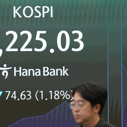 An employee walks past near the screen showing the Korea Composite Stock Price Index (KOSPI) at a dealing room of Hana Bank in Seoul, South Korea, Tuesday, Aug. 11, 2026. (AP Photo/Lee Jin-man)
