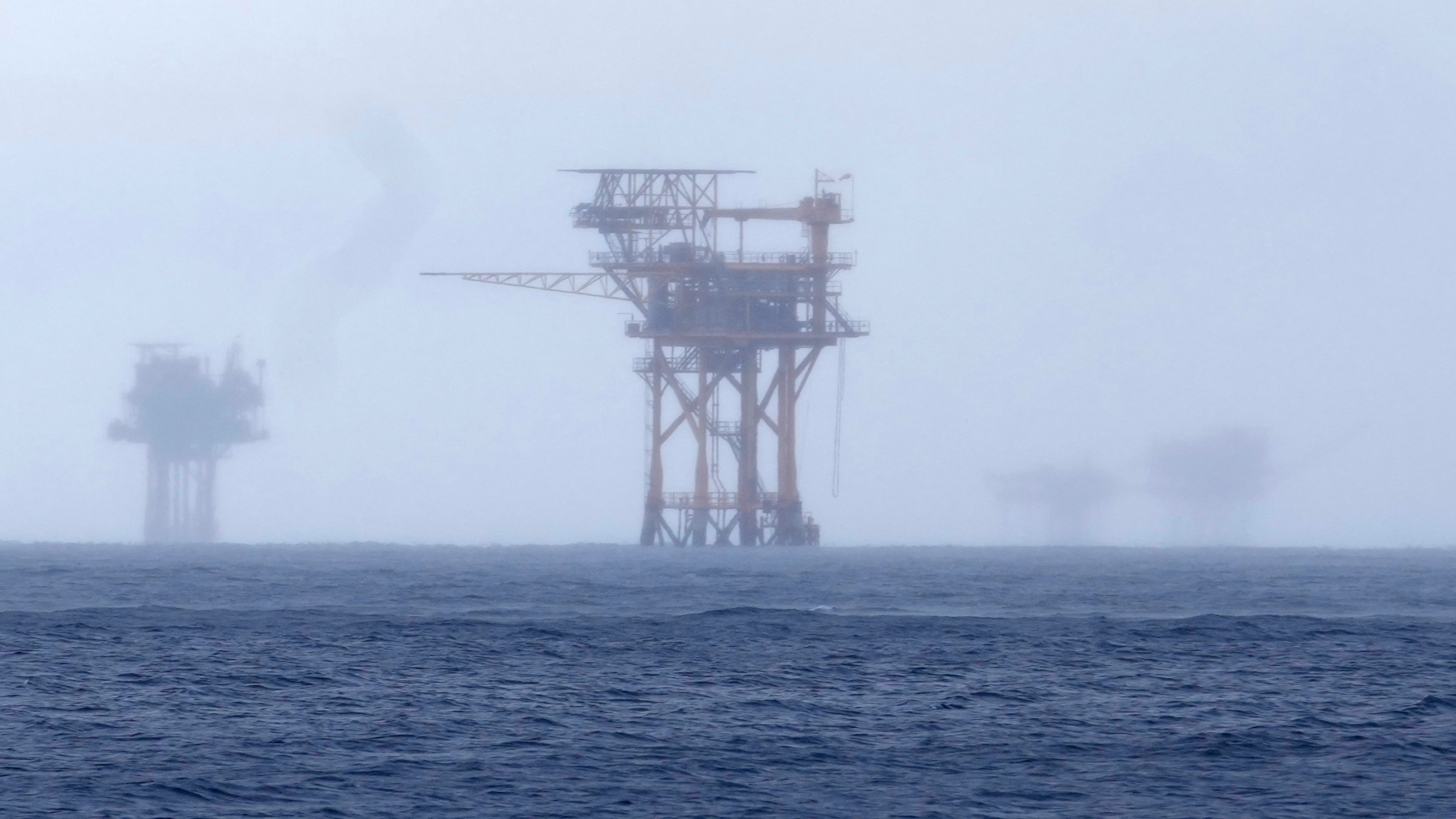 FILE - Oil platforms are visible through the haze near the Flower Garden Banks National Marine Sanctuary in the Gulf of Mexico, off the coast of Galveston, Texas, Saturday, Sept. 16, 2023. (AP Photo/LM Otero, File)