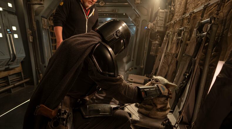 This image released by Disney shows director Jon Favreau, left, and Pedro Pascal on the set of Lucasfilm's "Star Wars: The Mandalorian and Grogu." (Francois Duhamel/Lucasfilm Ltd./Disney via AP)